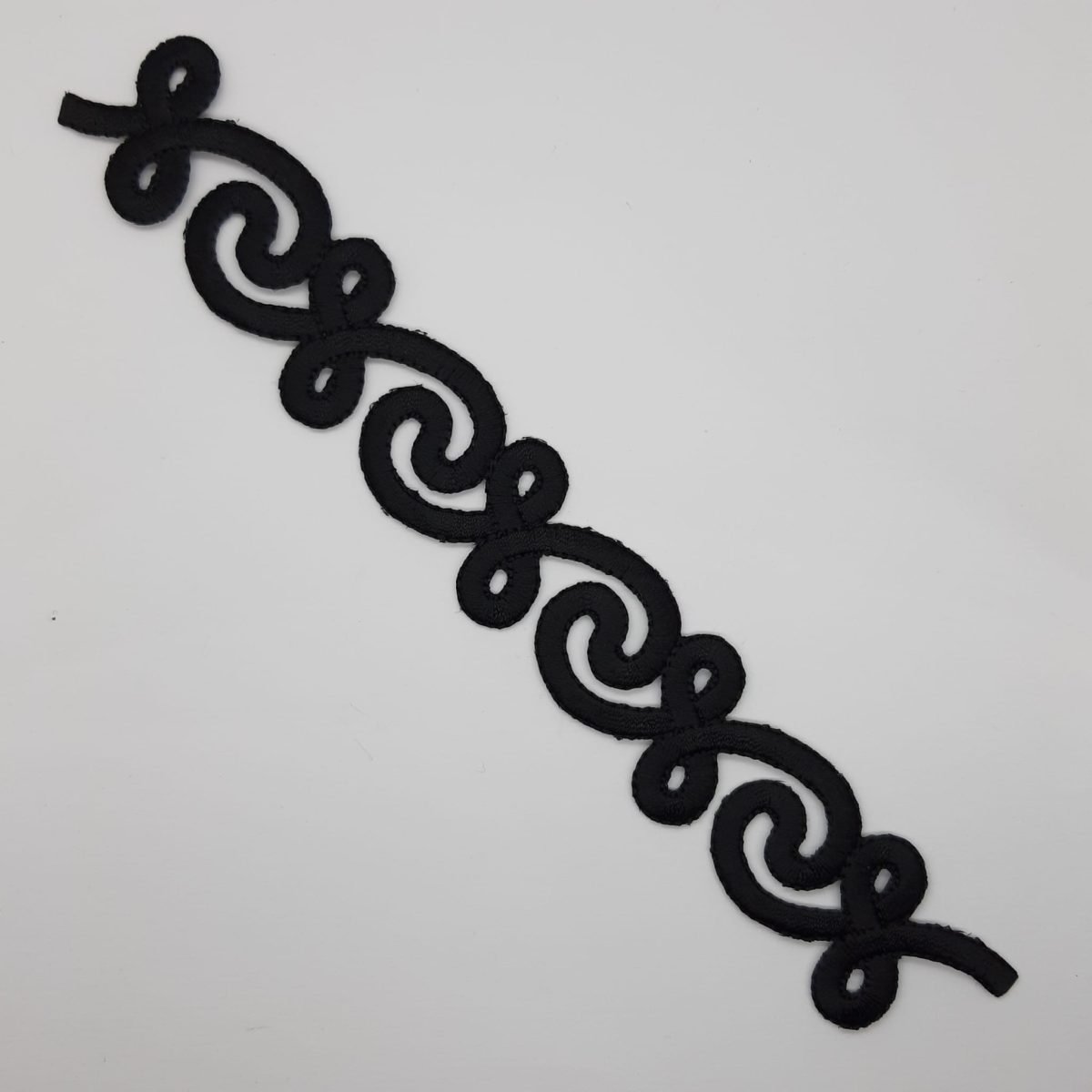 Aplicación bordada decorativa negra.