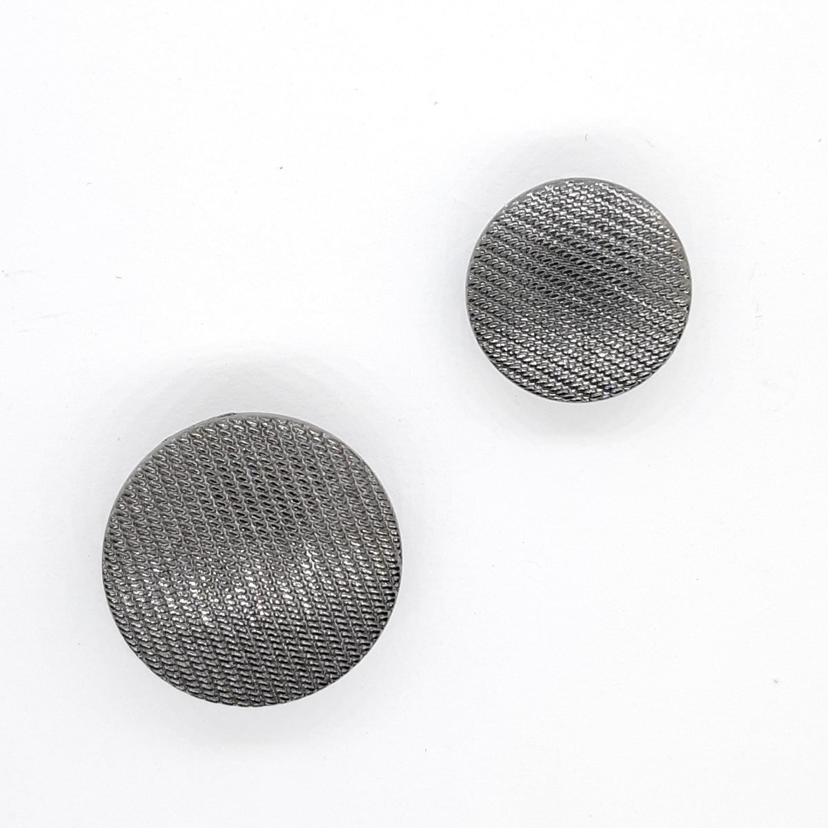 Botón metálico negro pavonado de rayas decorativas.