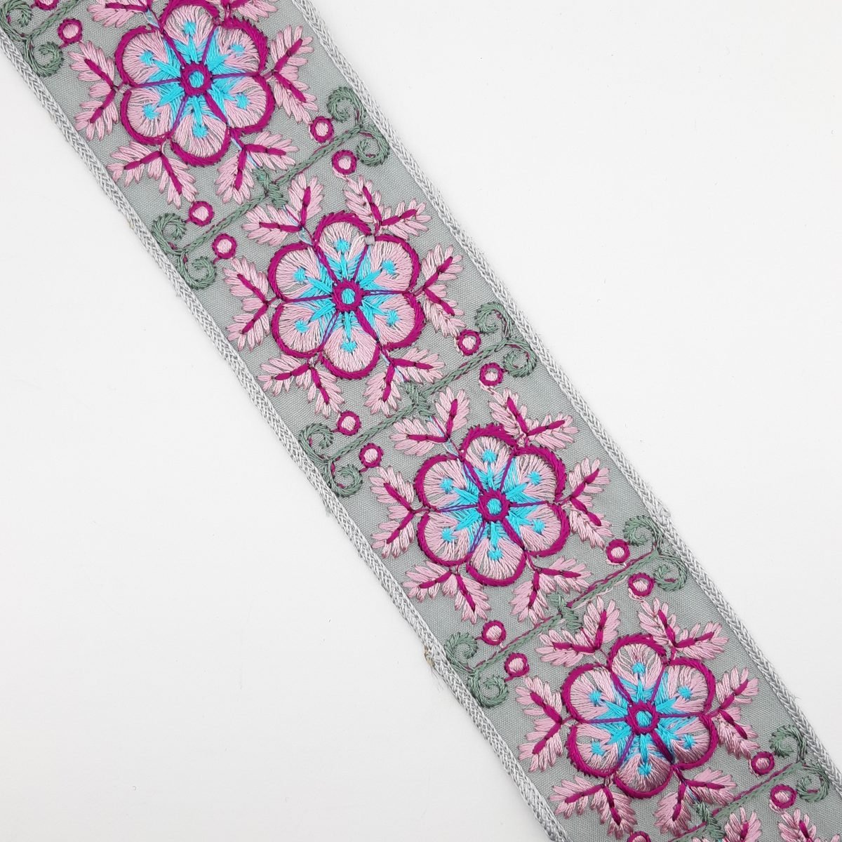 Galón tapacosturas bordado flor 5,5 cms gris, rosa y fucsia.