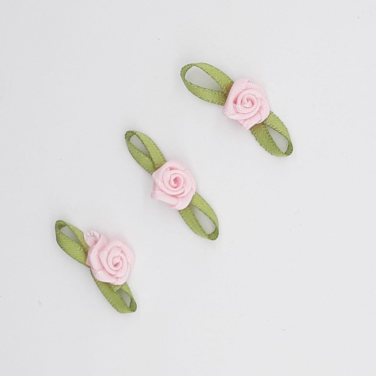 Flor de raso rosa con lazo verde decorativo